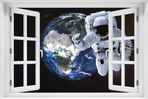 Fototapeta Naklejka Na Ścianę Okno 3D - Astronaut near the Earth planet of Solar system. Science fiction. Elements of the image are furnished by NASA