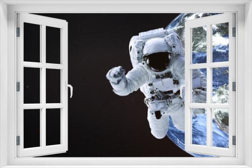 Fototapeta Naklejka Na Ścianę Okno 3D - Astronaut near the Earth planet of Solar system. Science fiction. Elements of the image are furnished by NASA