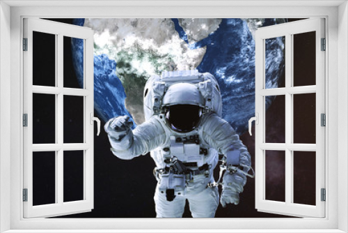 Fototapeta Naklejka Na Ścianę Okno 3D - Astronaut in a front of Earth planet of solar system. Science fiction. Elements of the image were furnished by NASA