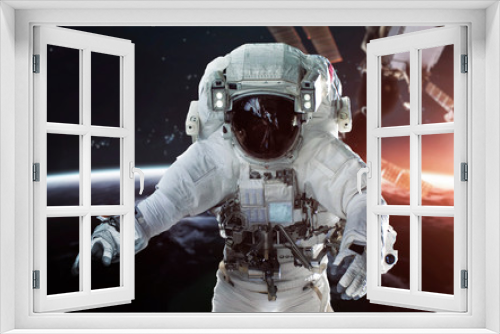 Fototapeta Naklejka Na Ścianę Okno 3D - Astronaut at the Earth orbit with the Space station behind. Elements of this image furnished by NASA