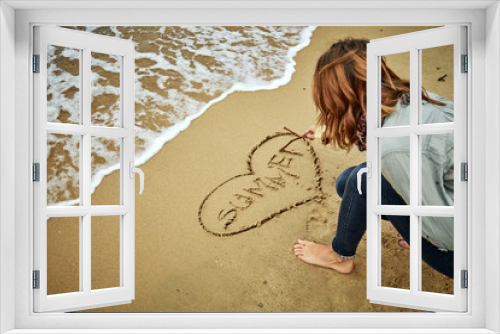 Fototapeta Naklejka Na Ścianę Okno 3D - Girl drawing a heart in the sand of ocean / sea beach.