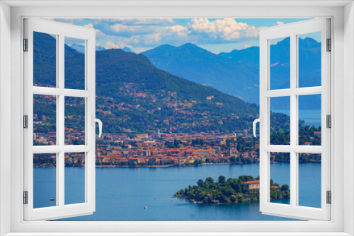 Fototapeta Naklejka Na Ścianę Okno 3D - AERIAL: Scenic view of a coastal town and islet in a beautiful Italian lake.