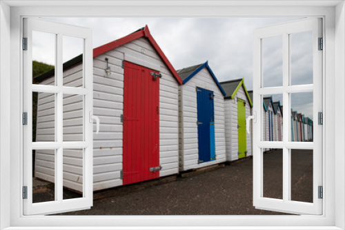 Fototapeta Naklejka Na Ścianę Okno 3D - Colorful beach huts with moody sky on Goodrington sands beach, Devon, England UK