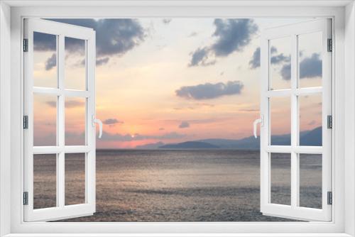 Fototapeta Naklejka Na Ścianę Okno 3D - beautiful sunrise over the sea, when the sun begins to rise over the horizon, beautifully illuminating the water and clouds, mountains in the background, a good background image