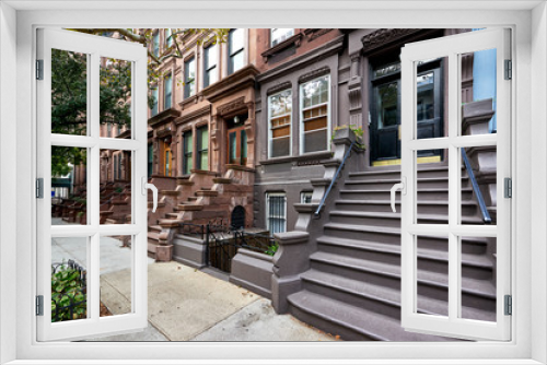 Fototapeta Naklejka Na Ścianę Okno 3D - a view of a row of historic brownstones in an iconic neighborhood of Manhattan, New York City