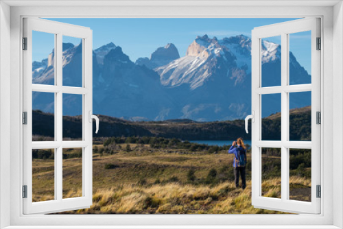 Fototapeta Naklejka Na Ścianę Okno 3D - Woman hiker takes picture of the Cordillera Paine mountains in the Torres del Paine National Park in Chile