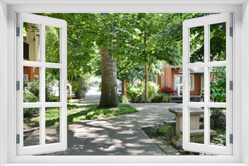 Fototapeta Naklejka Na Ścianę Okno 3D - A peaceful condo apartment neighborhood setting with trees and sidewalk.