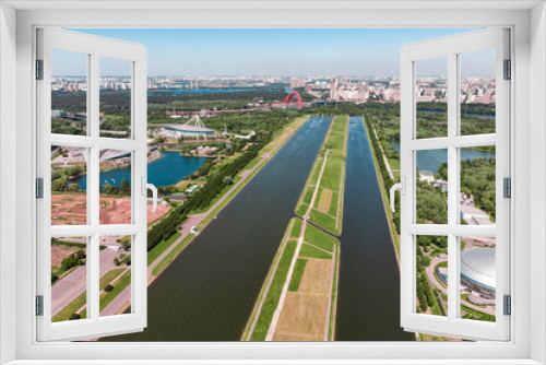 Fototapeta Naklejka Na Ścianę Okno 3D - Rowing canal illuminated by bright sunshine. Panoramic view. Shooting from above, aerial filming. Olympic rowing canal in Moscow.