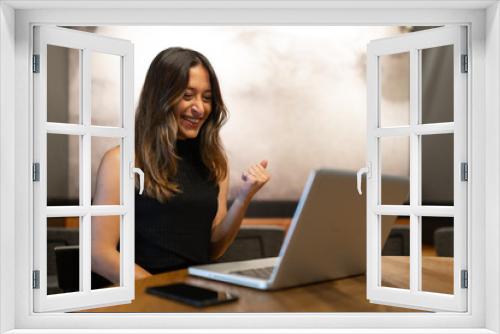 Business woman work process concept. Young woman working university project with generic design laptop. Happy excited woman at home workstation. Blurred background, film effect.