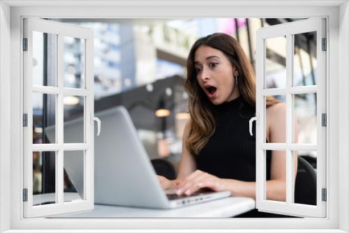 Business woman work process concept. Young woman working university project with generic design laptop. Happy excited woman at home workstation. Blurred background, film effect.