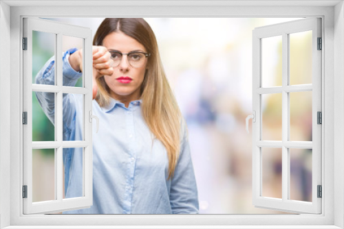 Young beautiful business woman wearing glasses over isolated background looking unhappy and angry showing rejection and negative with thumbs down gesture. Bad expression.