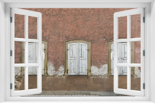 Fototapeta Naklejka Na Ścianę Okno 3D - Symmetrische Fassade von verlassenem, baufälligem Haus mit 3 Fenstern mit Fensterläden