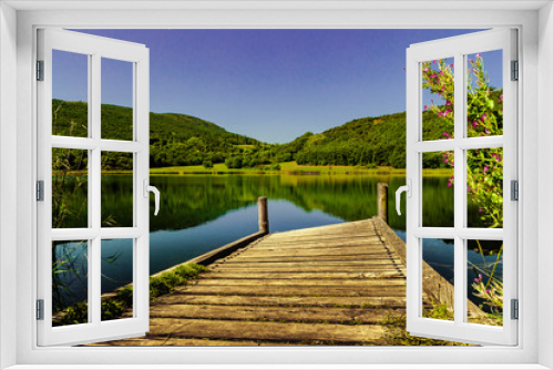 Fototapeta Naklejka Na Ścianę Okno 3D - old lake jetty surrounded by a green forest. A beautiful place to relax and feel the nature around.