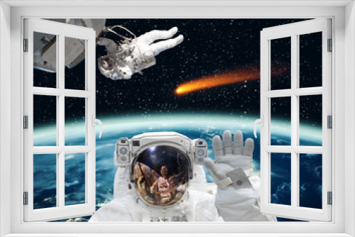 Fototapeta Naklejka Na Ścianę Okno 3D - Astronaut waving in front. Comet on the background. The elements of this image furnished by NASA.