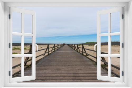 Fototapeta Naklejka Na Ścianę Okno 3D - Langer Holzsteg mit Sanddünen zum Meer
