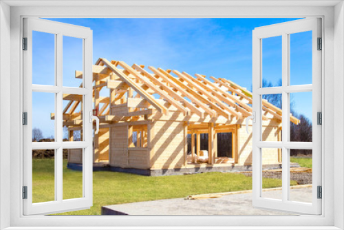 Fototapeta Naklejka Na Ścianę Okno 3D - Construction of cottage. Construction site. Project of the house from the profiled bar. Remodeling of the cottage. The house wooden base. Building of houses under the key. Production of wooden houses.