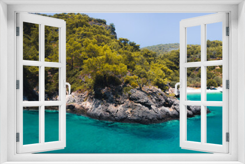 Fototapeta Naklejka Na Ścianę Okno 3D - Secluded beach surrounded by valley cliffs in a tranquil bay with turquoise water and sailing boats at sunrise, Oludeniz, Turkey panoramic