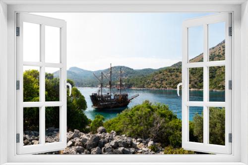 Fototapeta Naklejka Na Ścianę Okno 3D - Pirate ship moored in a secluded bay with turquoise water at sunset, Oludeniz, Turkey panoramic