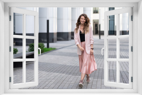 young light-skinned relaxed girl in fashionable clothes walks along the street with a great mood. Lifestyle