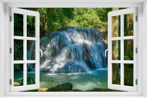 Fototapeta Naklejka Na Ścianę Okno 3D - The clean waterfall there is an emerald green colour caused by reflections from trees and lichen circulating through the yellow limestone. Huai Mae Khamin Waterfall, Kanchanaburi Province