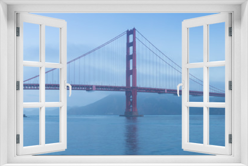 Fototapeta Naklejka Na Ścianę Okno 3D - Classic panoramic view of famous Golden Gate Bridge seen from San Francisco harbour in beautiful evening light on a dusk with blue sky and clouds and fog in summer, San Francisco, California, USA