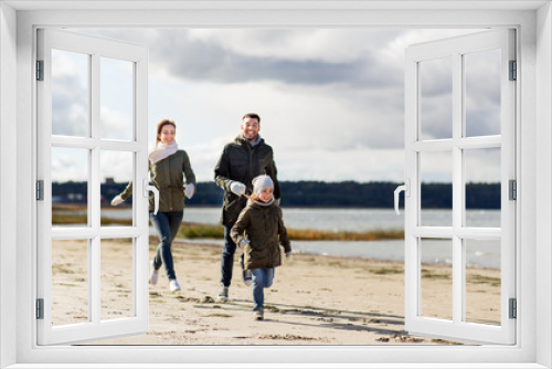 Fototapeta Naklejka Na Ścianę Okno 3D - family, leisure and people concept - happy mother, father and little daughter running along autumn beach