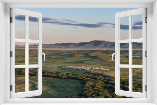 Fototapeta Naklejka Na Ścianę Okno 3D - The view from the mountain to the steppe is a traditional Kazakh cemetery, on the horizon you can see mountains, evening, clouds in the sky.
