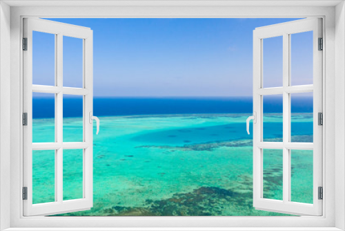 Fototapeta Naklejka Na Ścianę Okno 3D - Atoll and blue sea, view from above. Seascape by day. Turquoise and blue sea water.