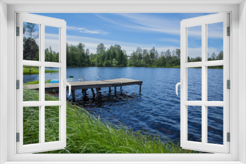 Fototapeta Naklejka Na Ścianę Okno 3D - Simple wooden jetty by the lake with high green grass in the foreground