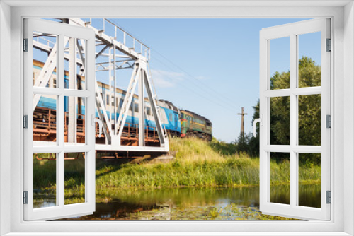 Fototapeta Naklejka Na Ścianę Okno 3D - Train runs through the  railway bridge over the river