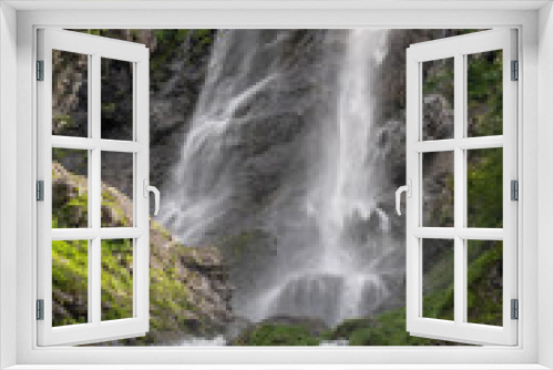 Fototapeta Naklejka Na Ścianę Okno 3D - A high waterfall falls from a cliff in spring or summer.