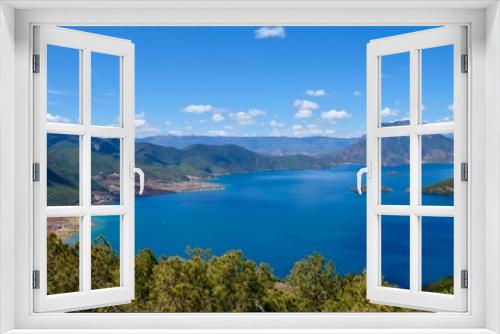 Fototapeta Naklejka Na Ścianę Okno 3D - deep blue lake surrounded by green mountains. Green trees foreground. Sunny blue sky with white clouds. high angle view of Lugu lake in Yunnan China
