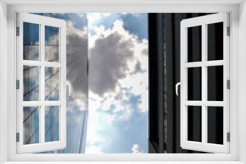 Fototapeta Naklejka Na Ścianę Okno 3D - View of high rise glass building with heart shape cloud reflected with a modern glass building and the blue sky in windows. Business concept of future architecture,looking up on the top of building. 