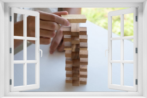 Fototapeta Naklejka Na Ścianę Okno 3D - hand playing blocks wood game, gambling placing wooden block. Concept Risk of management and strategy plan, growth business success process