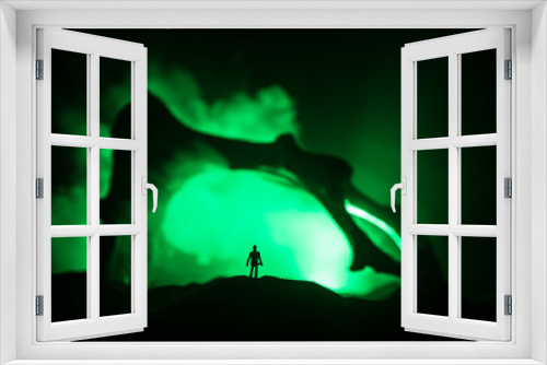 Fototapeta Naklejka Na Ścianę Okno 3D - Artwork decoration with animal bone. Silhouette in an underground abandoned crypt. man standing in front of a cave entrance
