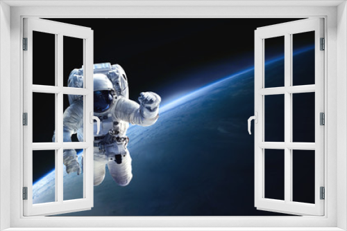 Fototapeta Naklejka Na Ścianę Okno 3D - Astronaut in the outer space over the planet Earth. Abstract wallpaper. Spaceman. Black bakground. Elements of this image furnished by NASA