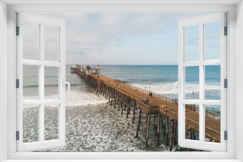 Fototapeta Naklejka Na Ścianę Okno 3D - OCEANSIDE, California (USA): Drone shot of the longest wooden maiden pier of the USA West Coast, Oceanside Pier. 
