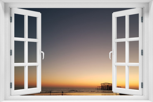Fototapeta Naklejka Na Ścianę Okno 3D - Beautiful sunset view at Brighton Pier with Brighton beach sea, sand and the oldest building in the background. Popular landmark of the city.