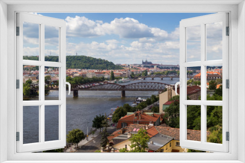 View of the city and bridges over the Vltava River in Prague, Czech Republic, on a sunny day in the summer. Prague (Hradcany) Castle is the background.