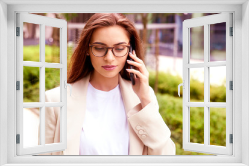 Young businesswoman making a call while walking on the street