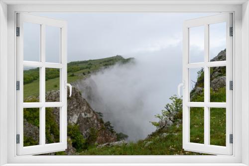 Fototapeta Naklejka Na Ścianę Okno 3D - heavy fog in the mountains after the rain with growing trees on the slope of a barely visible sea. Spring view of the Crimea.