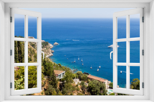 Fototapeta Naklejka Na Ścianę Okno 3D - Panoramic view from Taormina, in Sicily (Italy). A sunny summer day with beach, blue sky, boats and luxury houses. A cactus can be seen among the green vegetation in the foreground. – Image