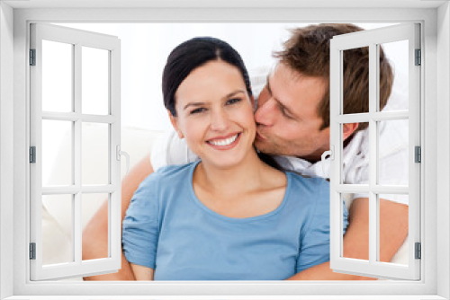 Lovely man kissing his girlfriend while relaxing on the sofa