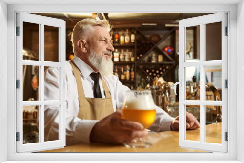 Professional male brewer standing over bar and drinking beer