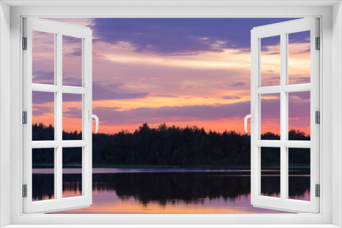 Fototapeta Naklejka Na Ścianę Okno 3D - dramatic sunset over a forest lake