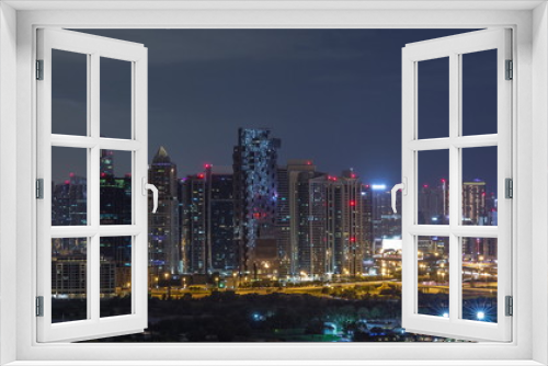 Fototapeta Naklejka Na Ścianę Okno 3D - Jumeirah lake towers and Dubai marina skyscrapers and golf course during all night timelapse, Dubai, United Arab Emirates
