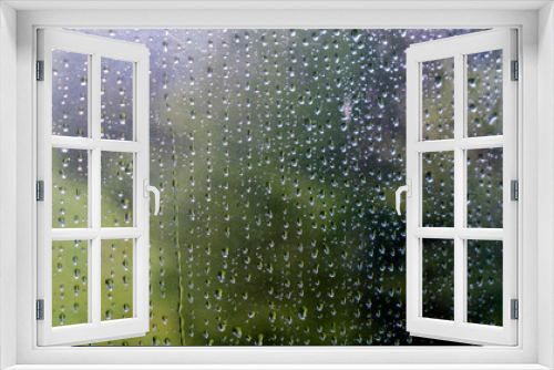 Fototapeta Naklejka Na Ścianę Okno 3D - Rain drops on window with green tree in background