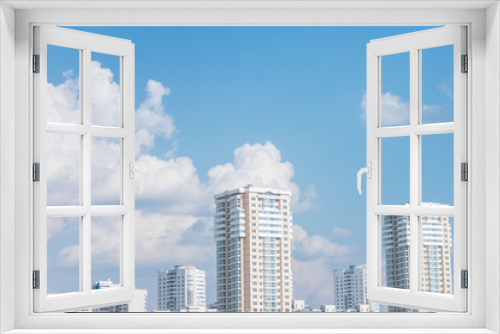 Sunny day in the city, apartment buildings, blue sky with clouds, copy space