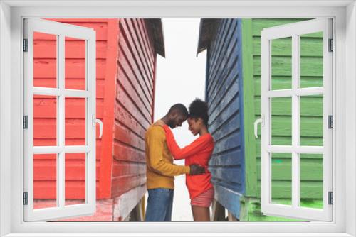 Romantic couple embracing each other between beach huts