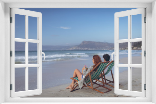 Fototapeta Naklejka Na Ścianę Okno 3D - Couple relaxing on sun lounger at beach 